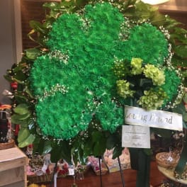 Large green floral standing spray with a "Loving Friend" ribbon
