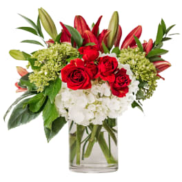 Red roses and white hydrangeas in a clear glass vase