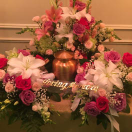 Large floral funeral arrangement with pink and white lilies and roses