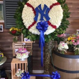 Large floral baseball wreath with a blue Yankees logo and ribbon