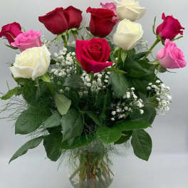 Bouquet of red, pink, and white roses in a clear glass vase