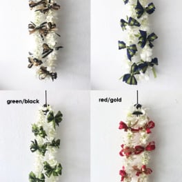 Four white floral leis with ribbon bows in different color combinations