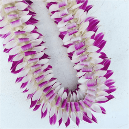 Two purple and white flower leis laid on a light surface.