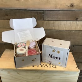 Two open gift boxes with candles and bath items, one labeled Mom