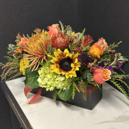 Mixed bouquet with sunflowers, roses, and hydrangeas in a black box