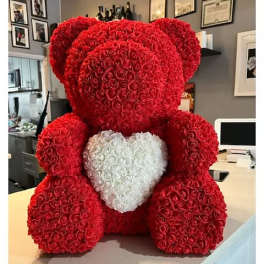 Large red rose teddy bear with a white heart on its chest