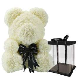White rose teddy bear with a black ribbon beside a clear gift box