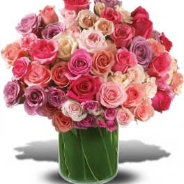 Bouquet of pink and lavender roses in a clear glass vase