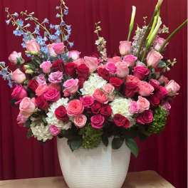 Large mixed bouquet of pink and red roses in a white vase