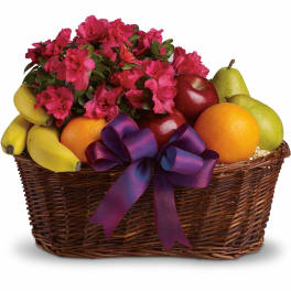 Basket of pink flowers and assorted fruit with a purple ribbon