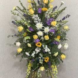 Tall standing floral spray with yellow, white, and purple flowers