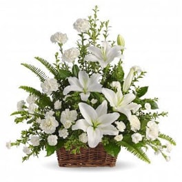 White lilies and carnations arranged in a wicker basket