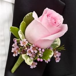 Pink rose boutonniere with small purple flowers on a black jacket