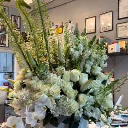 Large white floral arrangement in a round white container