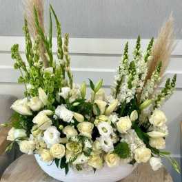 Large white floral arrangement in a low white container