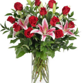 Red roses and pink lilies in a clear glass vase