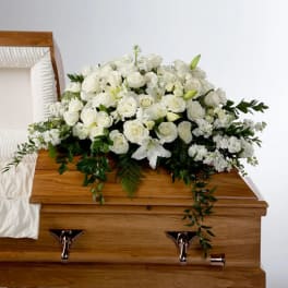 White floral spray on a wooden casket