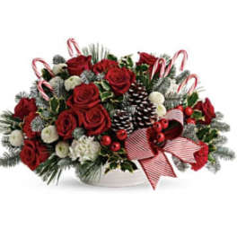 Red roses and holiday accents in a white bowl