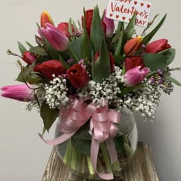 Bouquet of pink and red tulips with baby's breath and a Valentine's Day sign