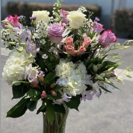 Mixed bouquet of pink and white roses in a clear glass vase