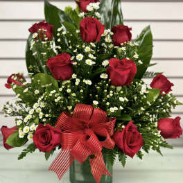 Red roses with white daisies in a green vase and red ribbon
