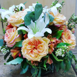 Bouquet of peach roses and white lilies with greenery