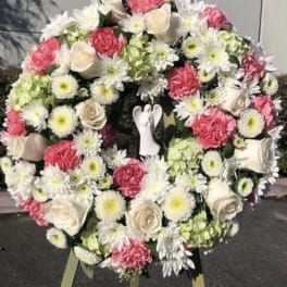 Large floral wreath with pink and white flowers on an easel