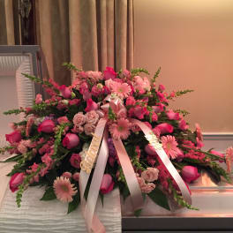 Large pink floral casket spray with ribbon streamers