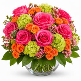 Bouquet of pink and orange roses with green hydrangeas in a glass vase