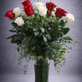 Red and white roses in a tall glass vase