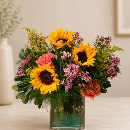 Sunflower and rose arrangement in a clear glass vase