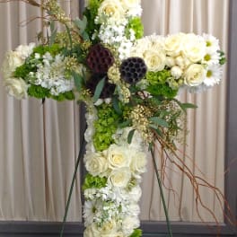 Large floral cross with white roses, daisies, and green hydrangeas