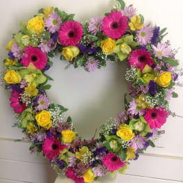 Heart-shaped floral wreath with pink, yellow, and lavender blooms