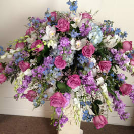 Large bouquet of pink roses, white orchids, and blue flowers