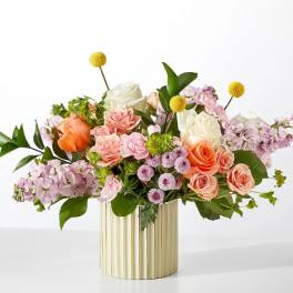 Mixed bouquet of roses and pastel flowers in a gold ribbed vase