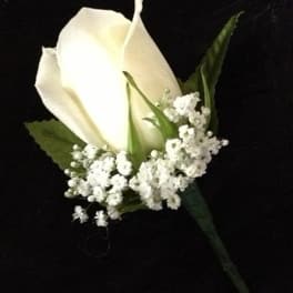 White rose boutonniere with baby's breath on a black background