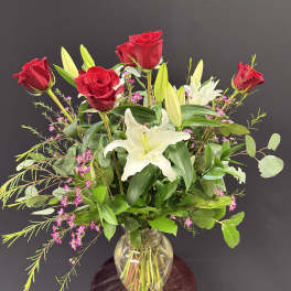 Red roses and white lilies in a clear glass vase