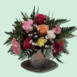 Mixed roses in a teacup vase on a saucer