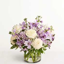 Lavender and white flower arrangement in a clear glass vase