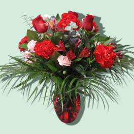 Red roses and carnations in a red glass vase