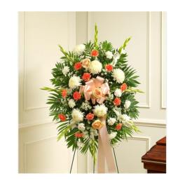 Standing floral wreath with white and orange flowers and a peach ribbon