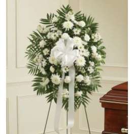 White funeral wreath on a stand with a ribbon bow