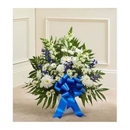 White and blue floral arrangement with a blue ribbon bow