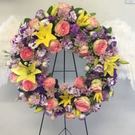 Floral wreath with pink and purple flowers and white feather wings