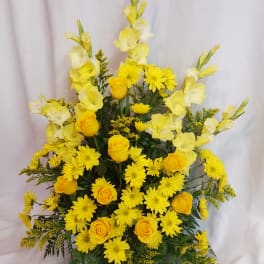 Yellow roses and daisies arranged in a tall bouquet