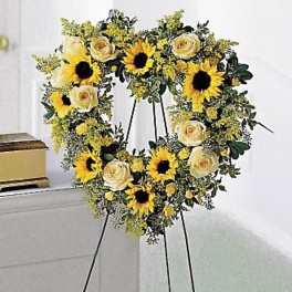 Sunflower and cream rose wreath on a black easel