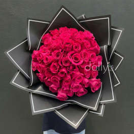 Bouquet of hot pink roses wrapped in black paper