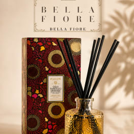 Decorative reed diffuser in a textured glass bottle with a patterned box