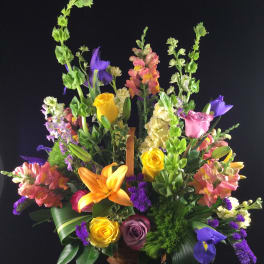 Colorful mixed flower arrangement in a basket with tall blooms