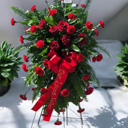 Standing red rose and carnation spray with a red ribbon